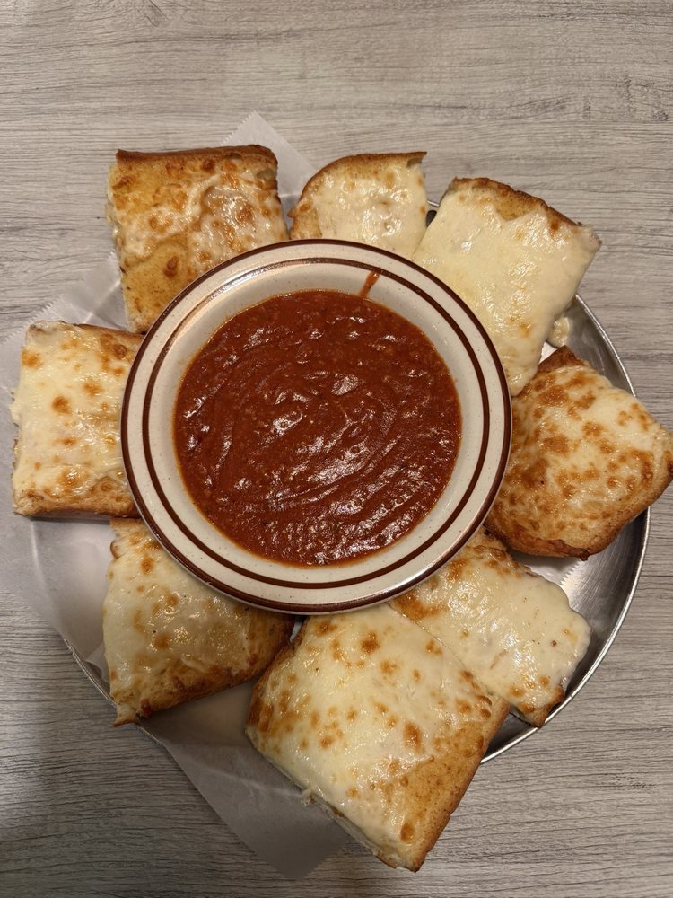 Cheese bread squares arranged around a bowl of meat sauce
